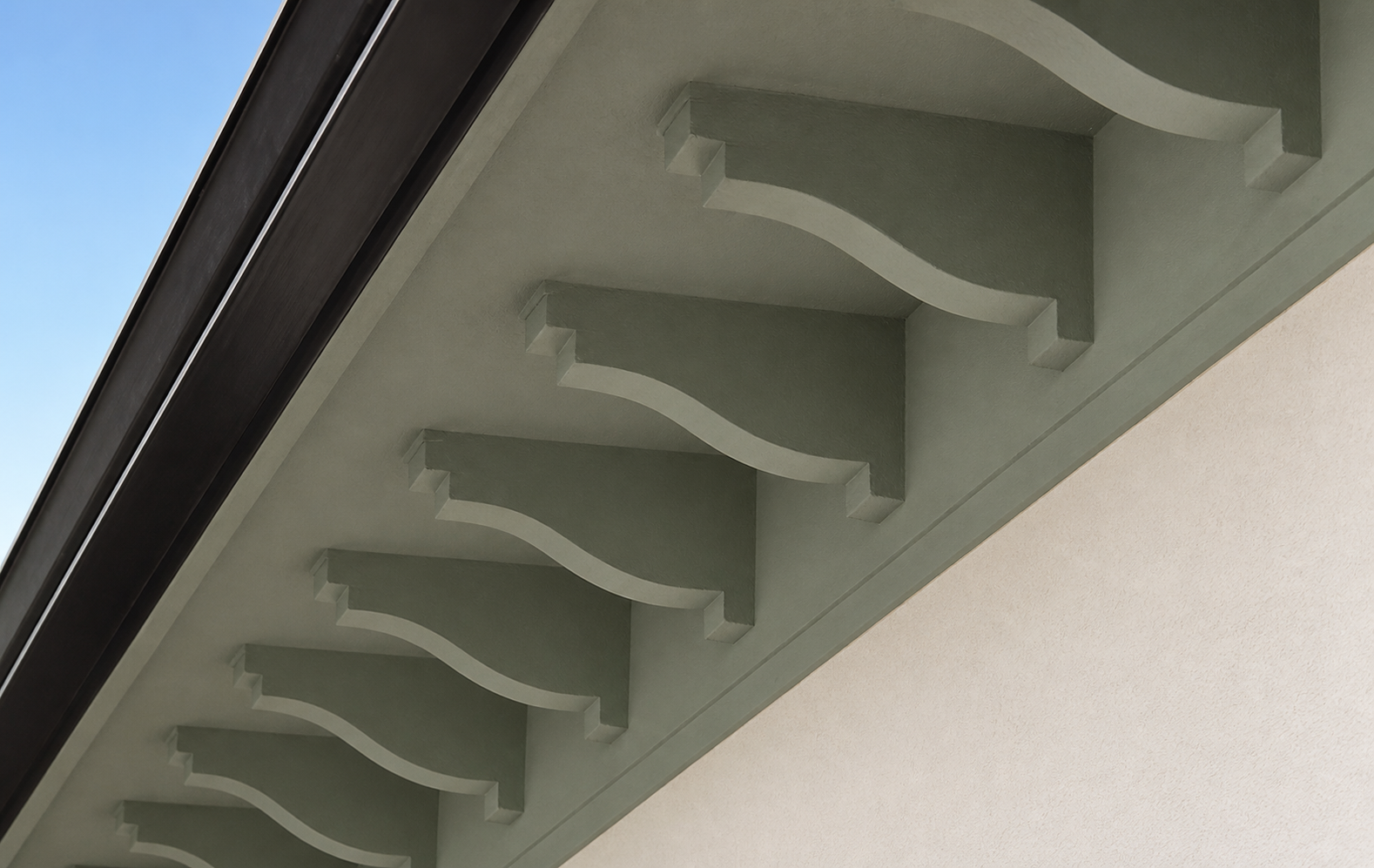 Close detail of painted decorative brackets beneath a roof eave
